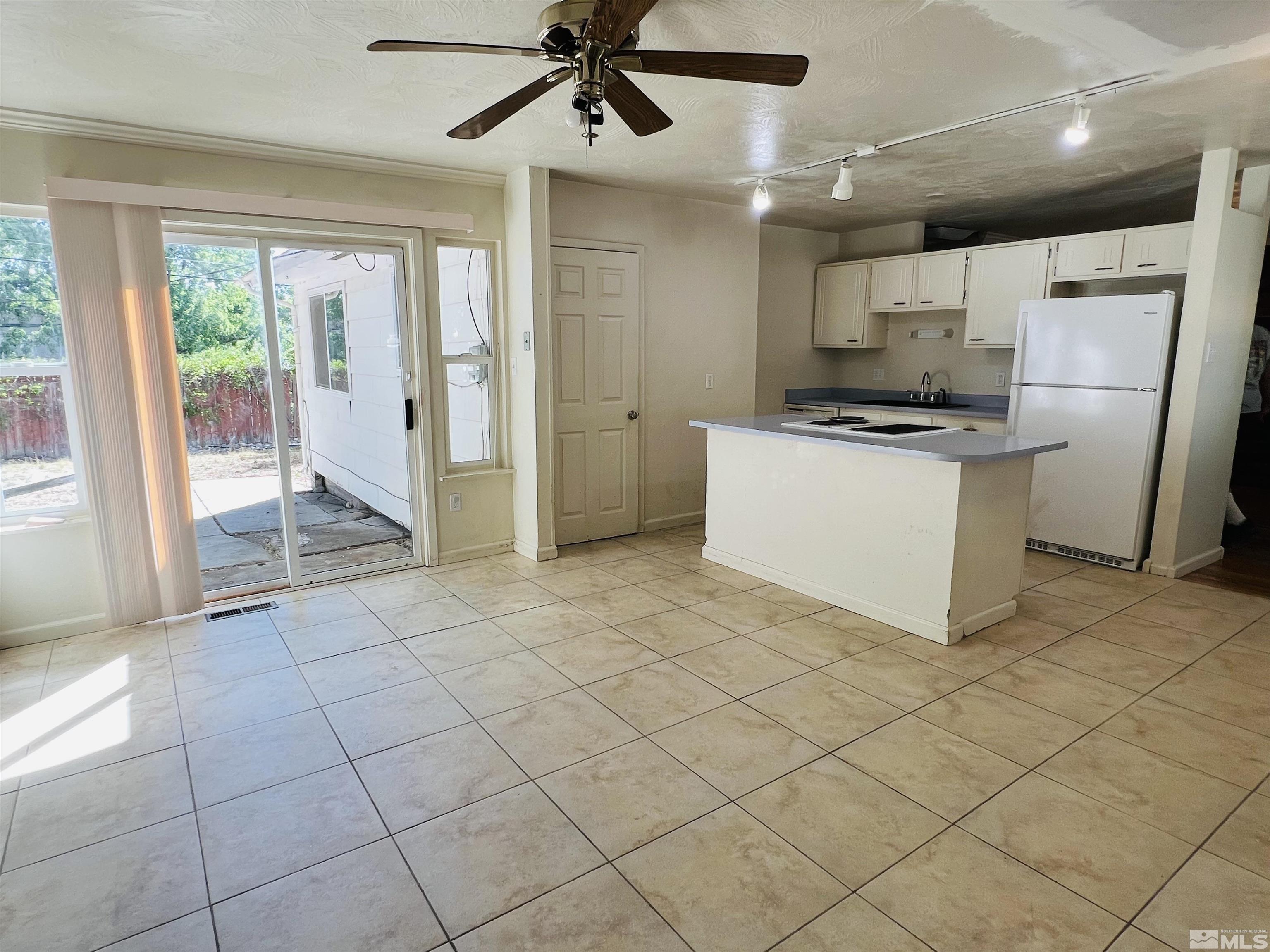 1430 Exeter Way Reno, NV 89503 - Photo 4 of 7 a kitchen with stainless steel appliances granite countertop a refrigerator a sink a stove and white cabinets
