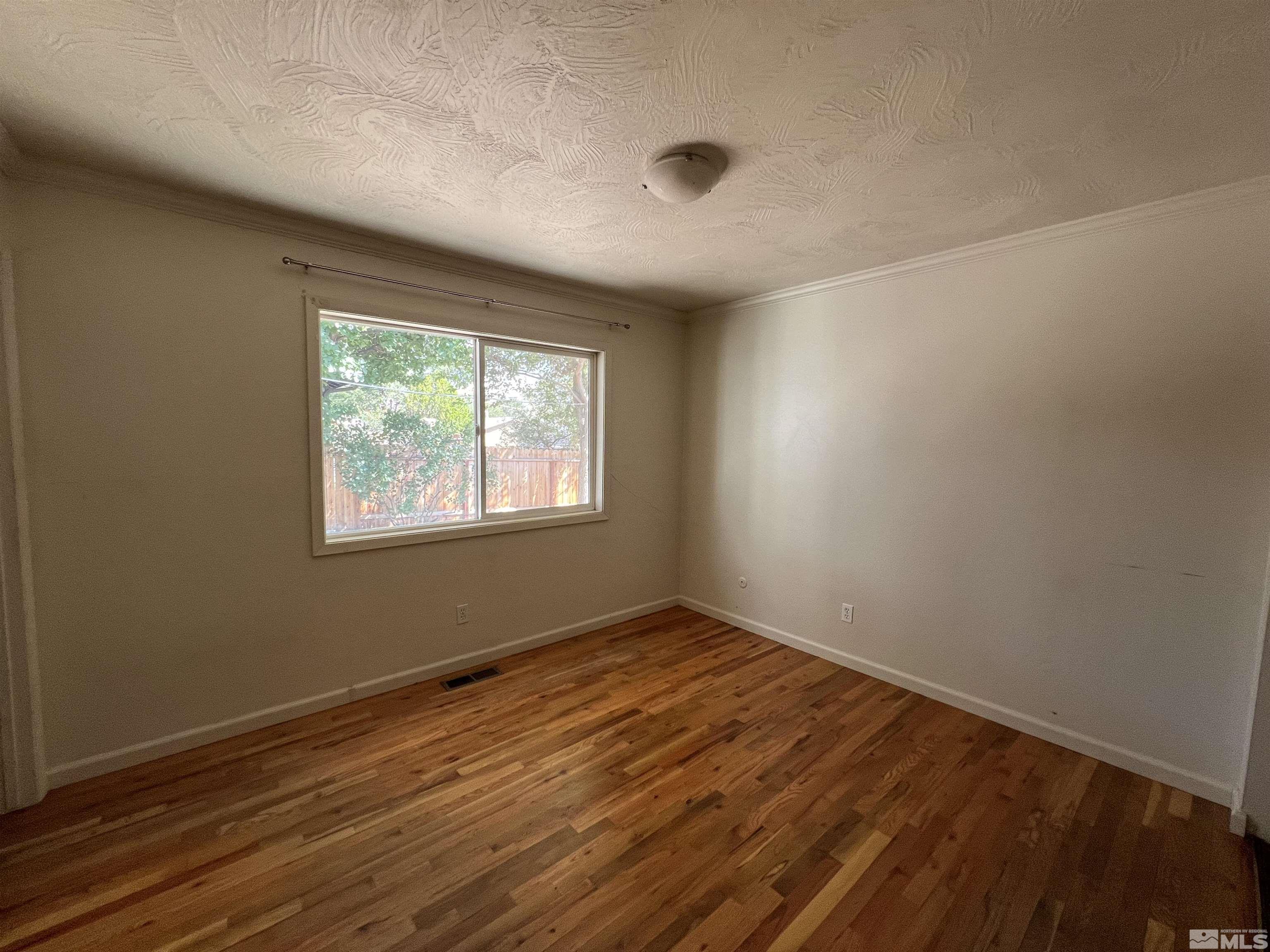 1430 Exeter Way Reno, NV 89503 - Photo 7 of 7 an empty room with wooden floor and windows