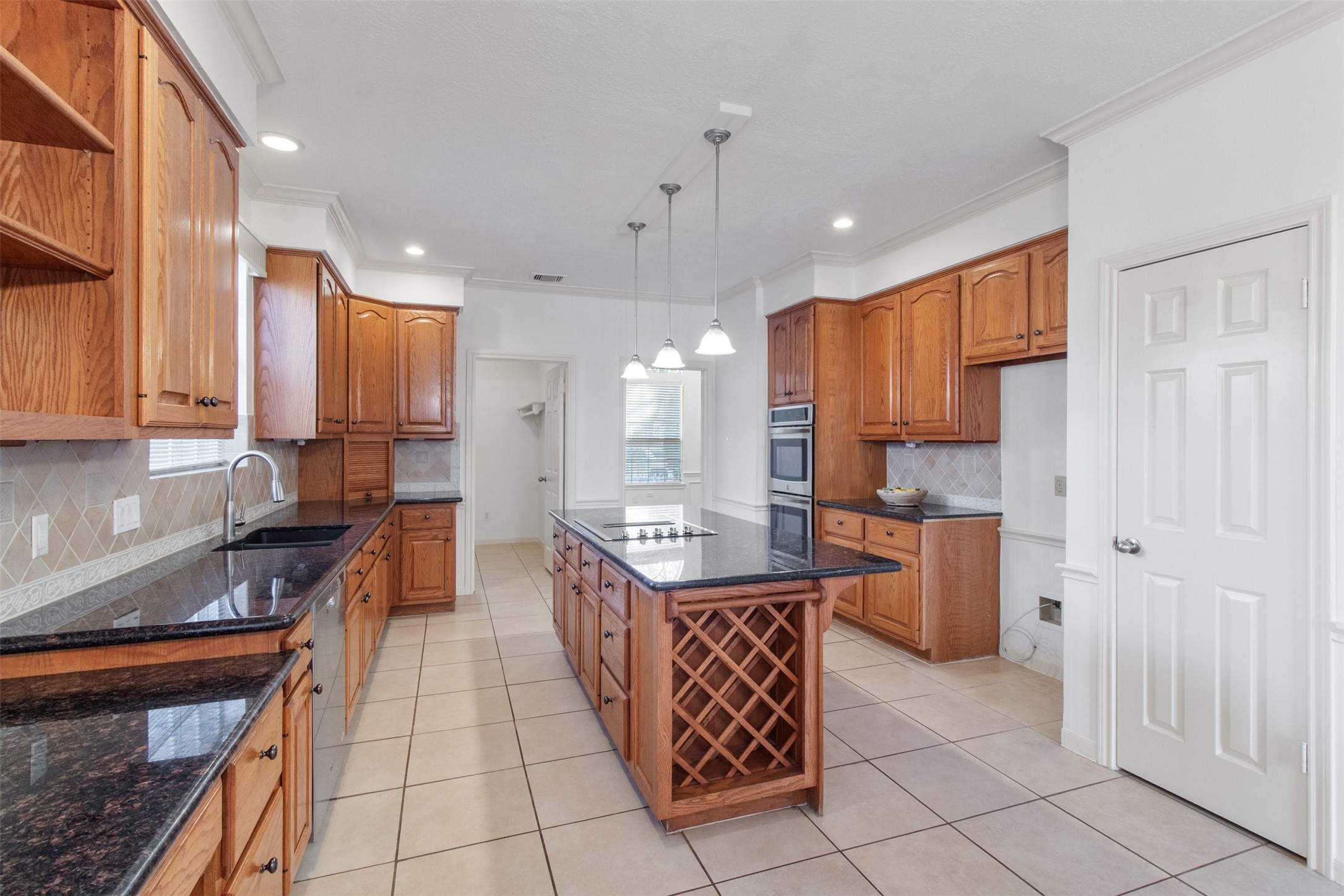 5127 Heathfield Court Houston, TX 77084 - Photo 12 of 37 Not only do you have a little built in desk area in the kitchen but you have a walk-in pantry, large island, wine storage and a built in oven.