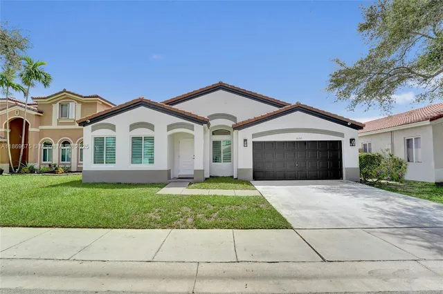 a front view of a house with a yard and garage