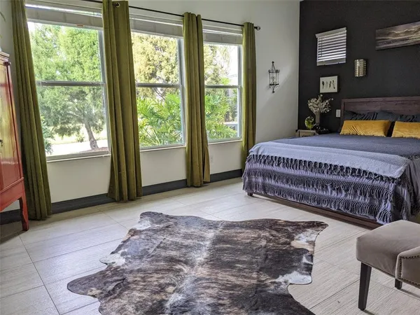 a spacious bedroom with a bed a table and a window