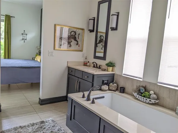 a bathroom with a tub sink and mirror