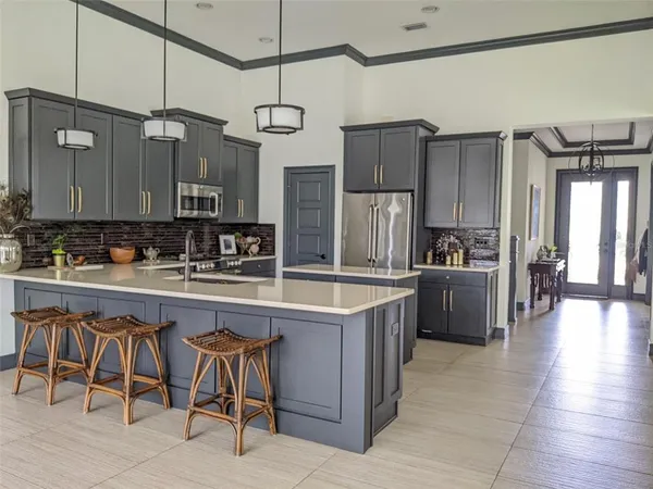 a kitchen with refrigerator and chairs