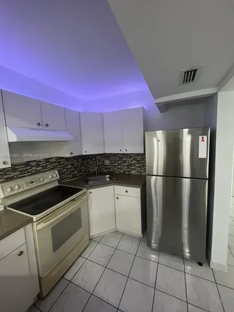 a kitchen with a stove a refrigerator and cabinets