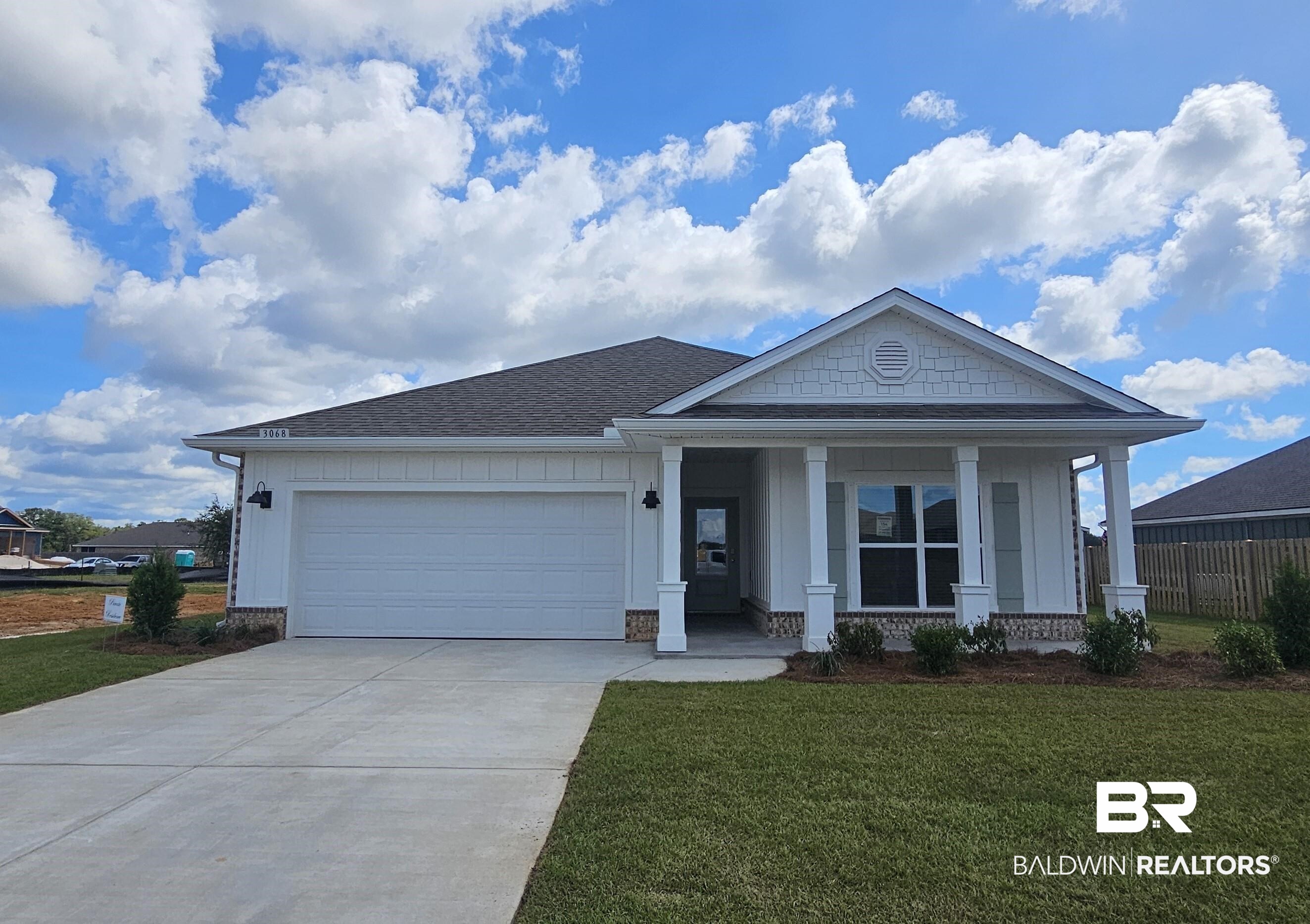 3068 Gallica Lane Foley, AL 36535 - Photo 1 of 38 View of front facade featuring a front yard, a porch, roof with shingles, driveway, and a garage