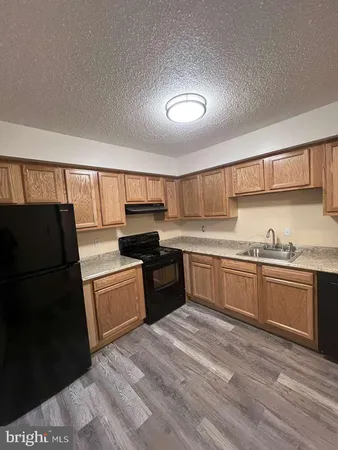 a kitchen with granite countertop stainless steel appliances and wooden cabinets