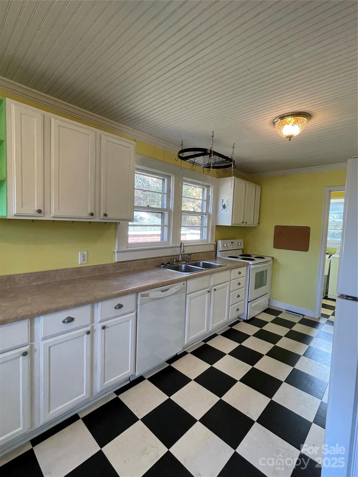 2711 Mooresville Road Salisbury, NC 28147 - Photo 6 of 18 a kitchen with a checkered floor and white cabinets