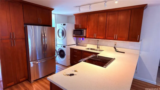 a kitchen with appliances a sink and a refrigerator