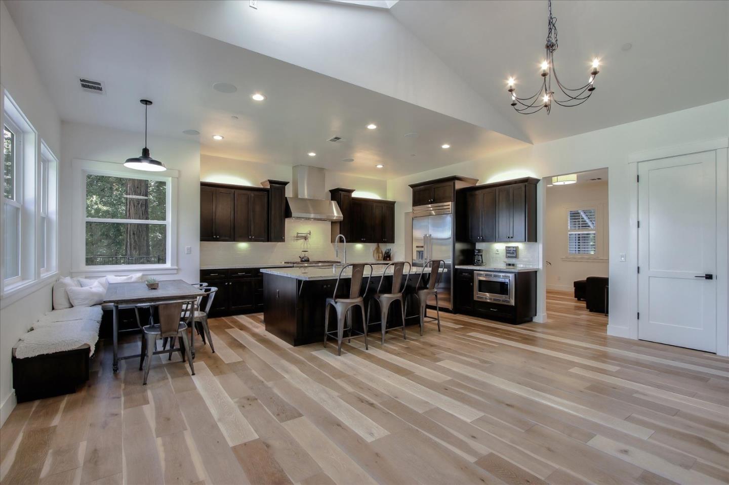 355 McKee Road Felton, CA 95018 - Photo 19 of 71 a kitchen with stainless steel appliances kitchen island granite countertop a stove top oven a sink dishwasher a dining table and chairs with wooden floor