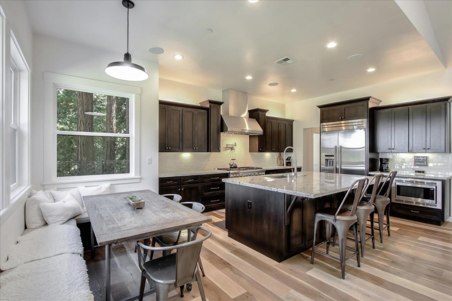 355 McKee Road Felton, CA 95018 - Photo 25 of 71 a kitchen with stainless steel appliances granite countertop a stove a refrigerator a kitchen island a sink dishwasher a dining table and chairs with wooden floor