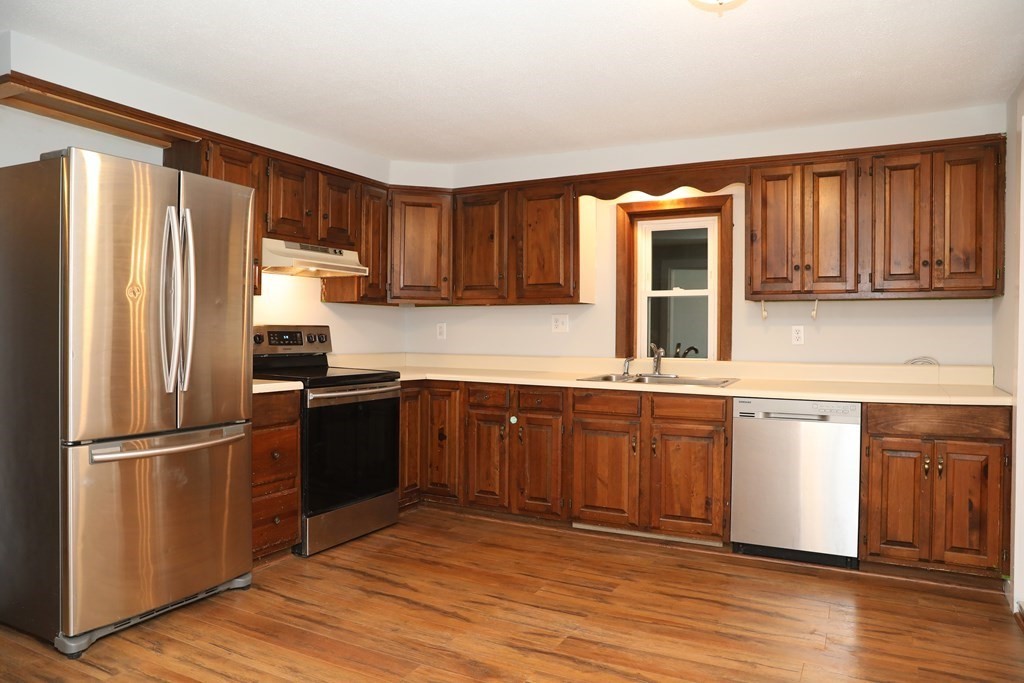 57 Springfield Street Three Rivers, MA 01080 - Photo 3 of 25 a kitchen with granite countertop wooden cabinets a refrigerator and a sink
