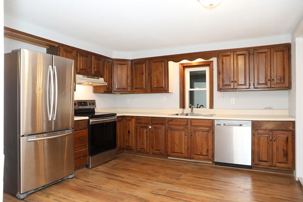 57 Springfield Street Three Rivers, MA 01080 - Photo 7 of 25 a kitchen with granite countertop wooden floors stainless steel appliances and a window
