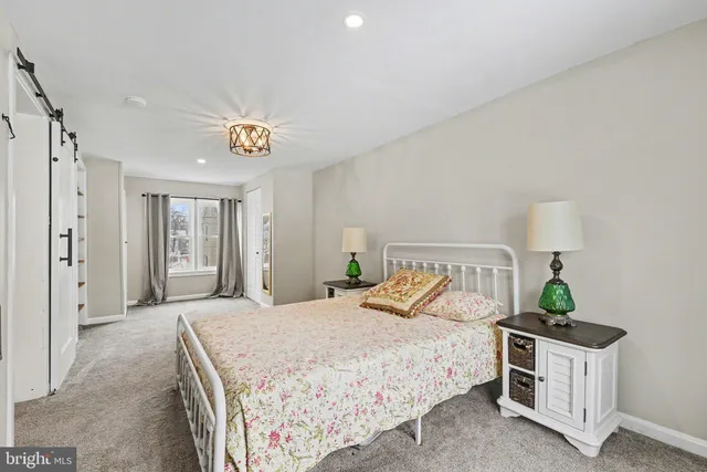 a bedroom with a large bed and a chandelier