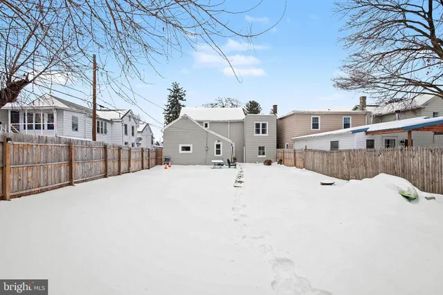 a view of residential houses with yard and wooden fence