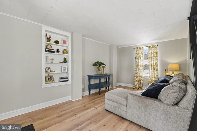 a spacious bedroom with a bed painting on wall and a window