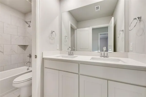 a bathroom with a double vanity sink toilet and shower