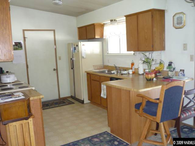 3455 Becard Lane Reno, NV 89508 - Photo 2 of 9 a kitchen with stainless steel appliances granite countertop a stove a refrigerator and a microwave