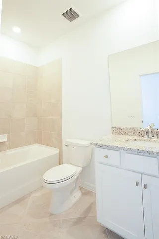 a bathroom with a granite countertop toilet a sink and a bathtub