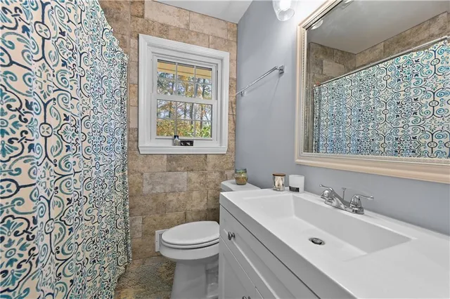 a bathroom with a sink a toilet and a window