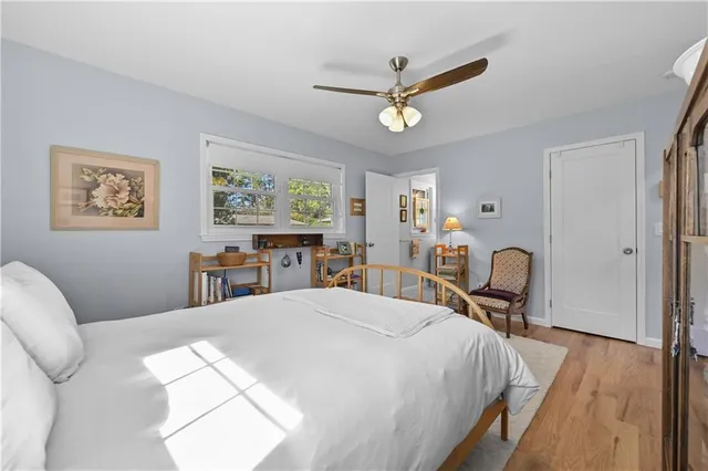 a bedroom with a bed a window and painting on the wall