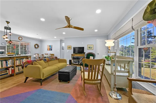 a living room with furniture kitchen view and a large window