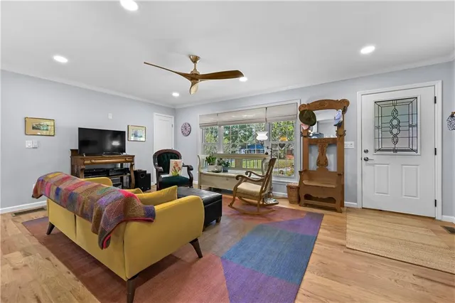 a living room with furniture a flat screen tv and a floor to ceiling window