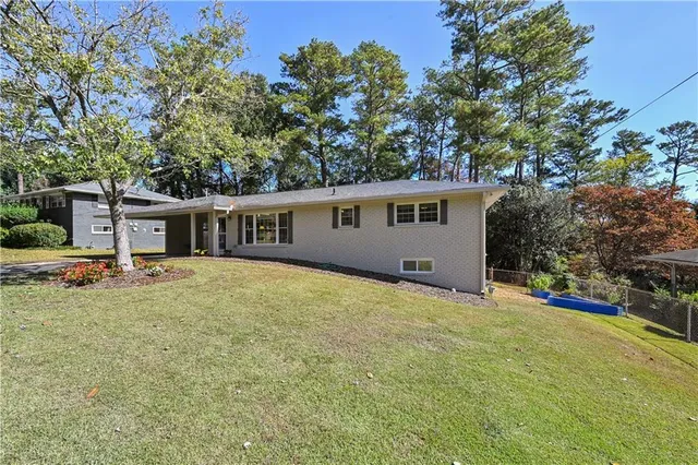 a front view of house with yard and trees in the background