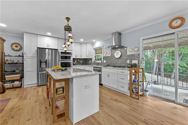 a kitchen with kitchen island granite countertop a stove and a wooden floors