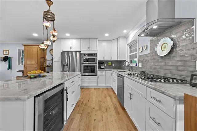 a large kitchen with stainless steel appliances granite countertop a stove a sink and a microwave