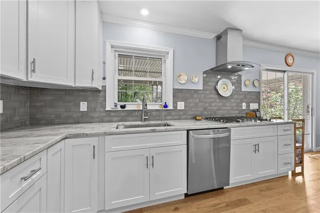 a kitchen with granite countertop white cabinets and window