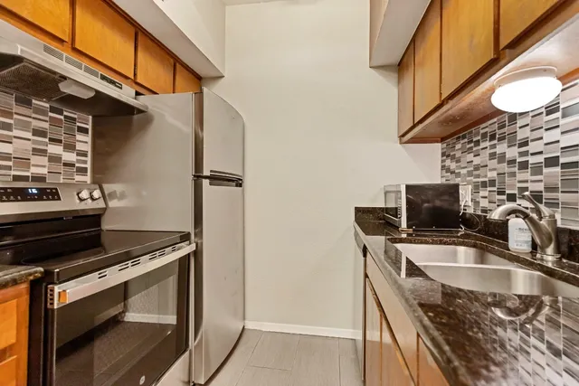 a kitchen with stainless steel appliances a stove a sink and a microwave