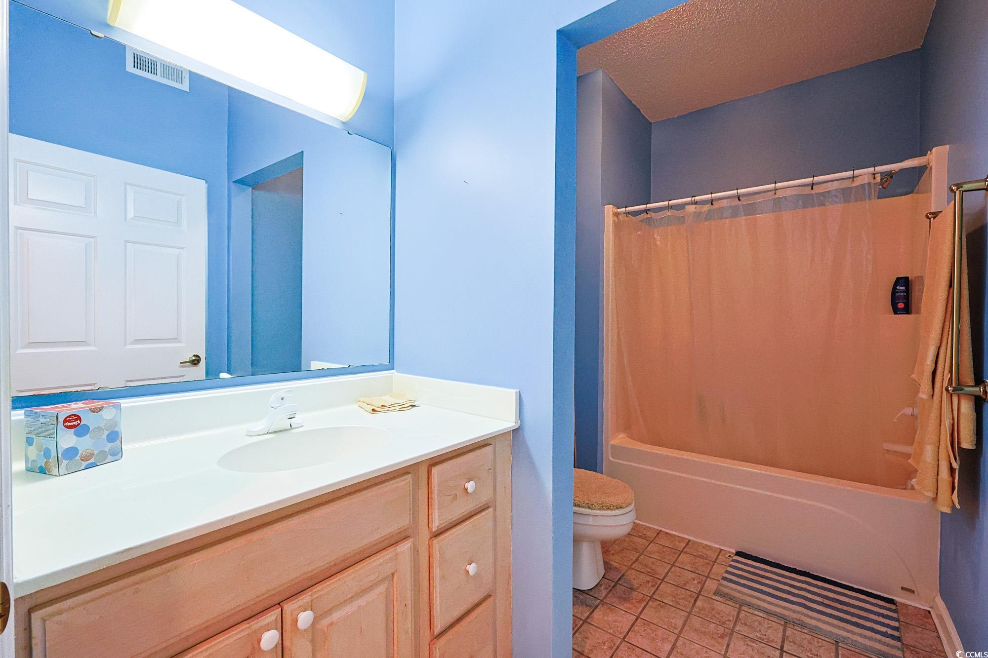 2302 Sweetwater Boulevard, Unit 2302 Murrells Inlet, SC 29576 - Photo 14 of 24 Full bathroom featuring shower / bathtub combination with curtain, vanity, and light tile patterned floors