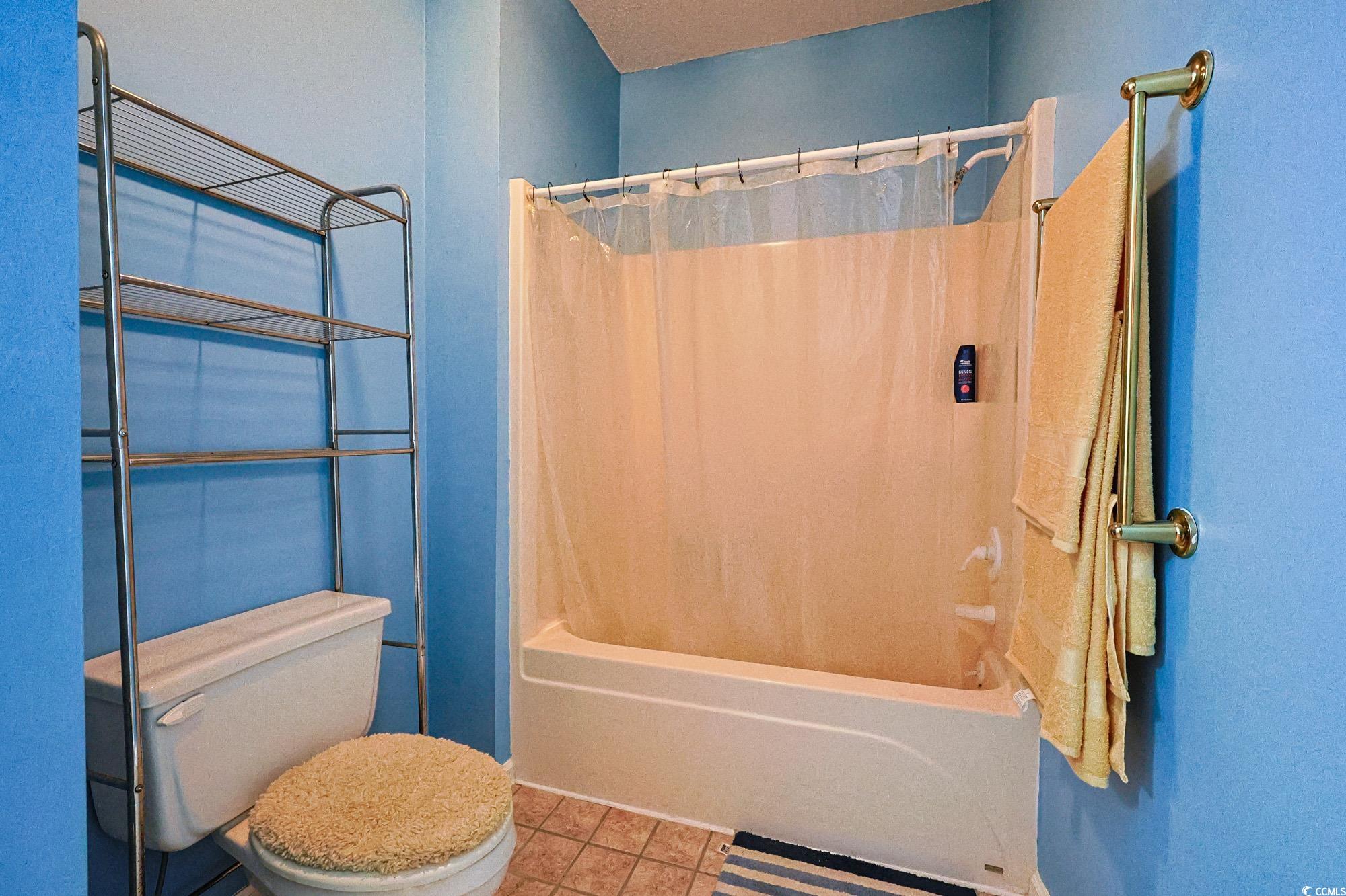 2302 Sweetwater Boulevard, Unit 2302 Murrells Inlet, SC 29576 - Photo 15 of 24 Bathroom featuring shower / bath combination with curtain and tile patterned flooring