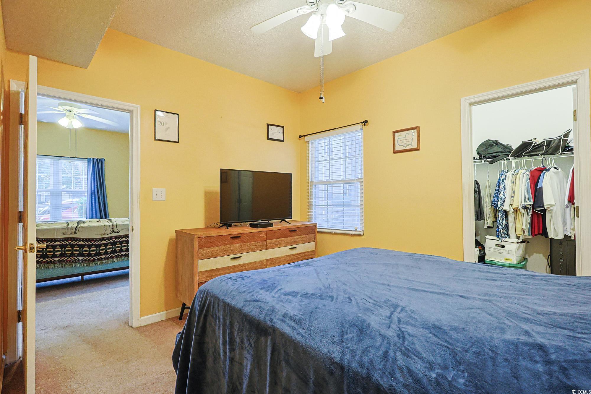 2302 Sweetwater Boulevard, Unit 2302 Murrells Inlet, SC 29576 - Photo 18 of 24 Bedroom with light colored carpet, a spacious closet, and ceiling fan