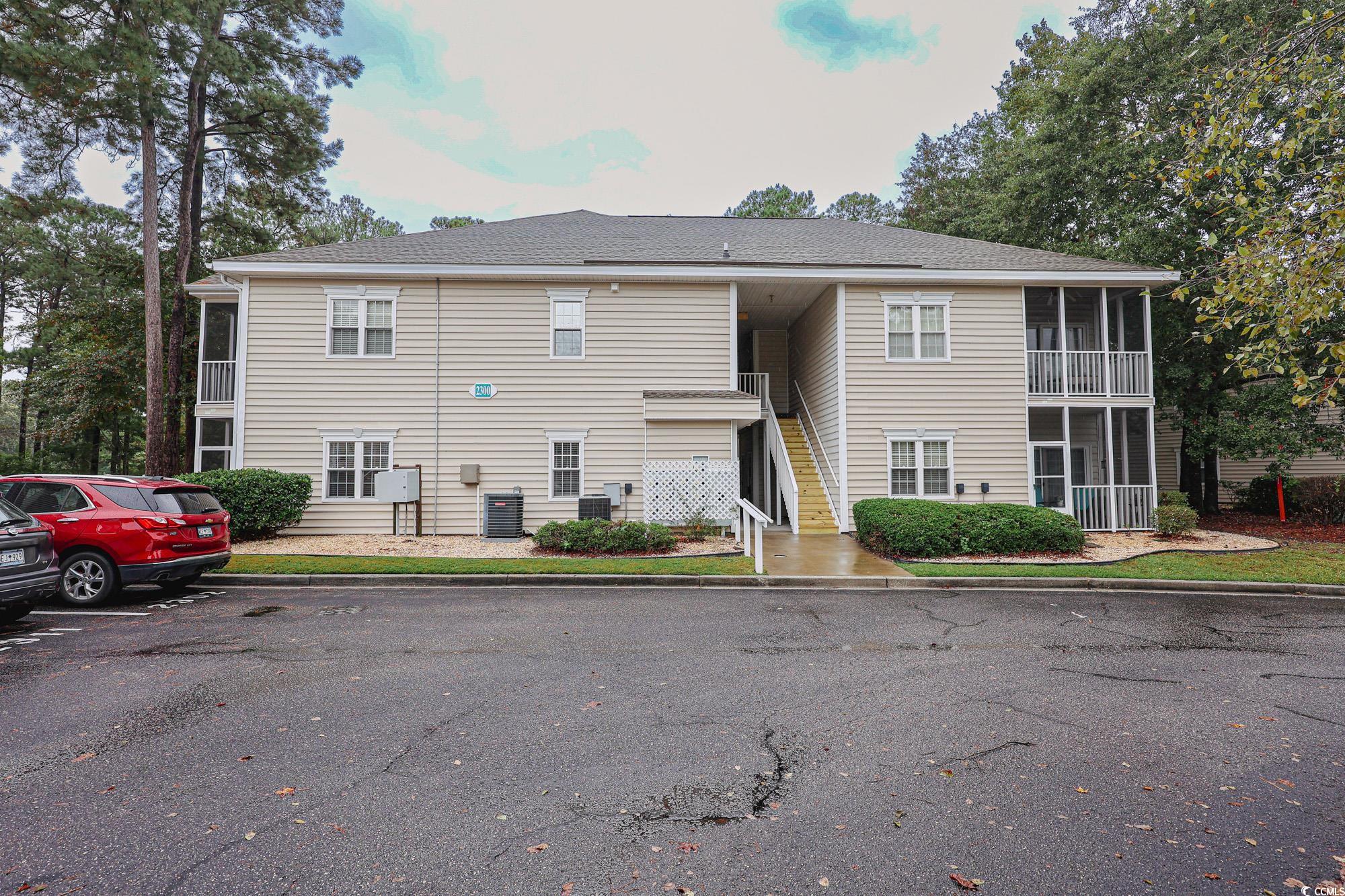 2302 Sweetwater Boulevard, Unit 2302 Murrells Inlet, SC 29576 - Photo 23 of 24 View of building exterior featuring stairway and uncovered parking