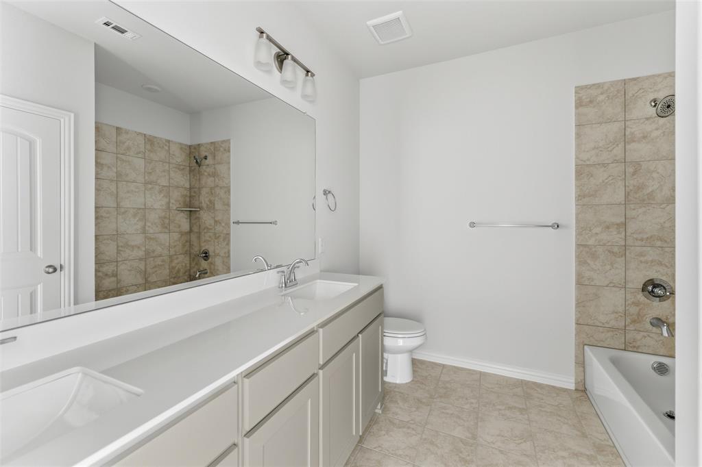 1221 Sabine River Lane Springtown, TX 76082 - Photo 12 of 25 Full bath with double vanity, shower combination, and light tile patterned floors