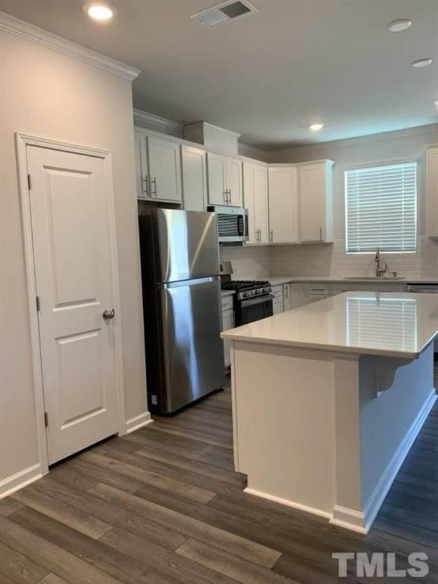 6518 Tremolo Trail, Unit C Raleigh, NC 27616 - Photo 4 of 8 a kitchen with a refrigerator sink and cabinets