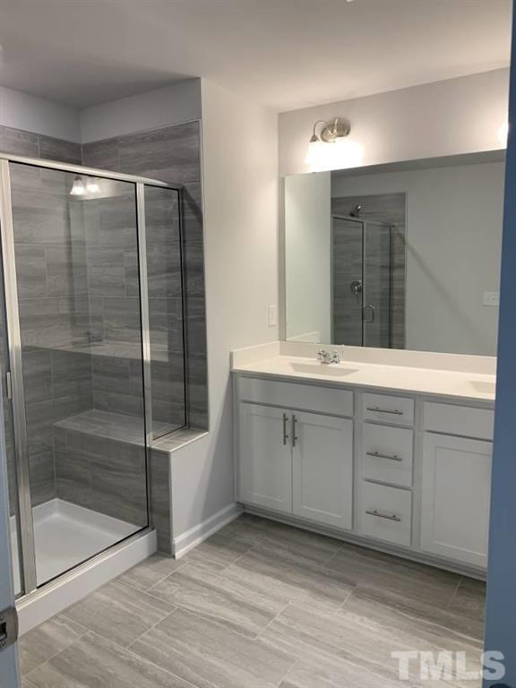 6518 Tremolo Trail, Unit C Raleigh, NC 27616 - Photo 6 of 8 a bathroom with a shower sink and mirror