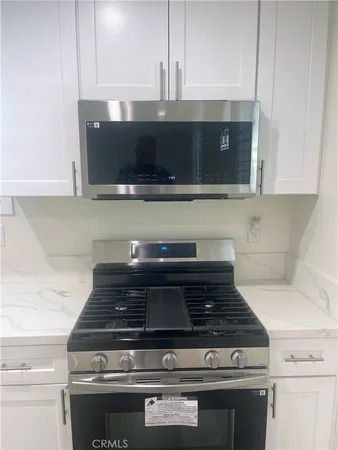 a stove top oven sitting inside of a kitchen