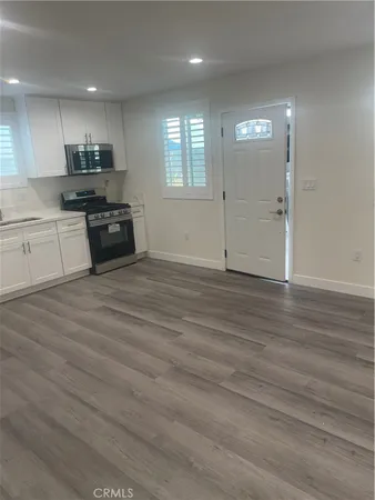 an empty room with wooden floor and window