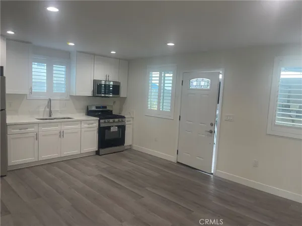 a kitchen with a white cabinets and window