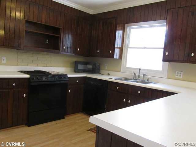 10819 Cherokee Road Midlothian, VA 23113 - Photo 9 of 24 a kitchen with a sink a stove and cabinets