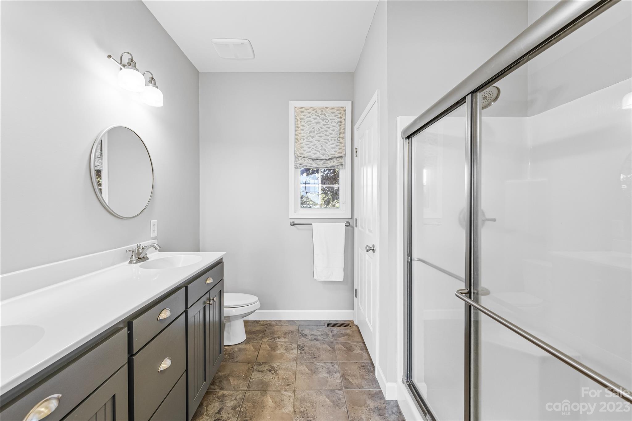 5423 Reepsville Road Vale, NC 28168 - Photo 21 of 48 a bathroom with a sink a toilet a mirror and a shower