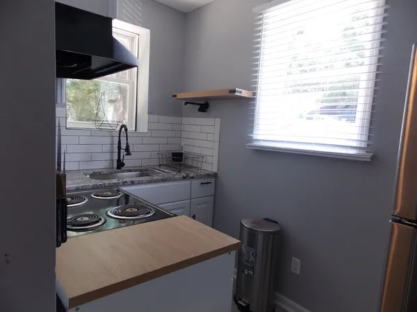 a kitchen with a stove a sink and a window