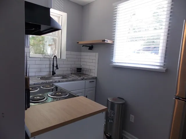 a kitchen with a stove a sink and a window