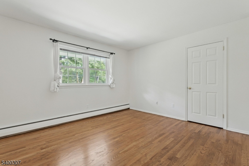 247 Spencer Road Bernards, NJ 07920 - Photo 26 of 48 a view of an empty room with wooden floor and a window