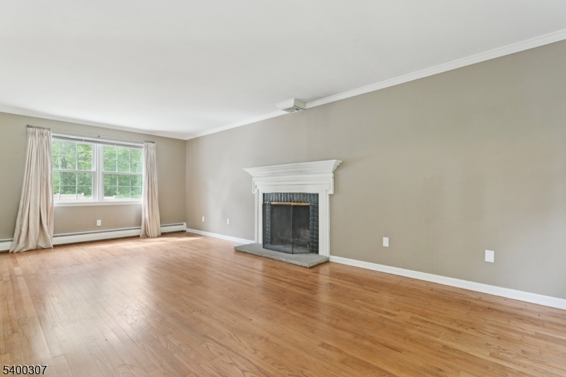 247 Spencer Road Bernards, NJ 07920 - Photo 3 of 48 a view of an empty room with wooden floor and a window