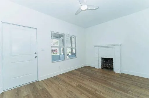 an empty room with windows and fireplace