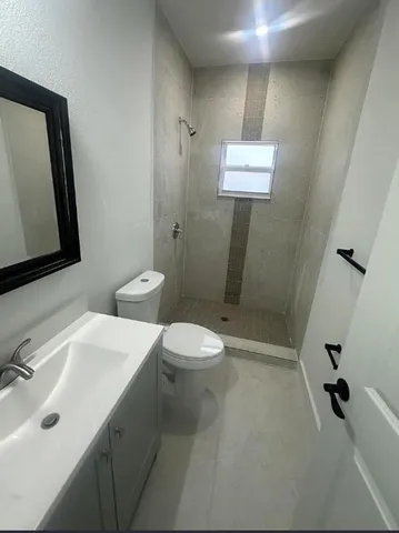 a bathroom with a toilet sink shower and mirror