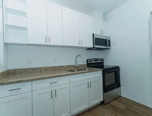 a kitchen with stainless steel appliances granite countertop white cabinets a sink and dishwasher